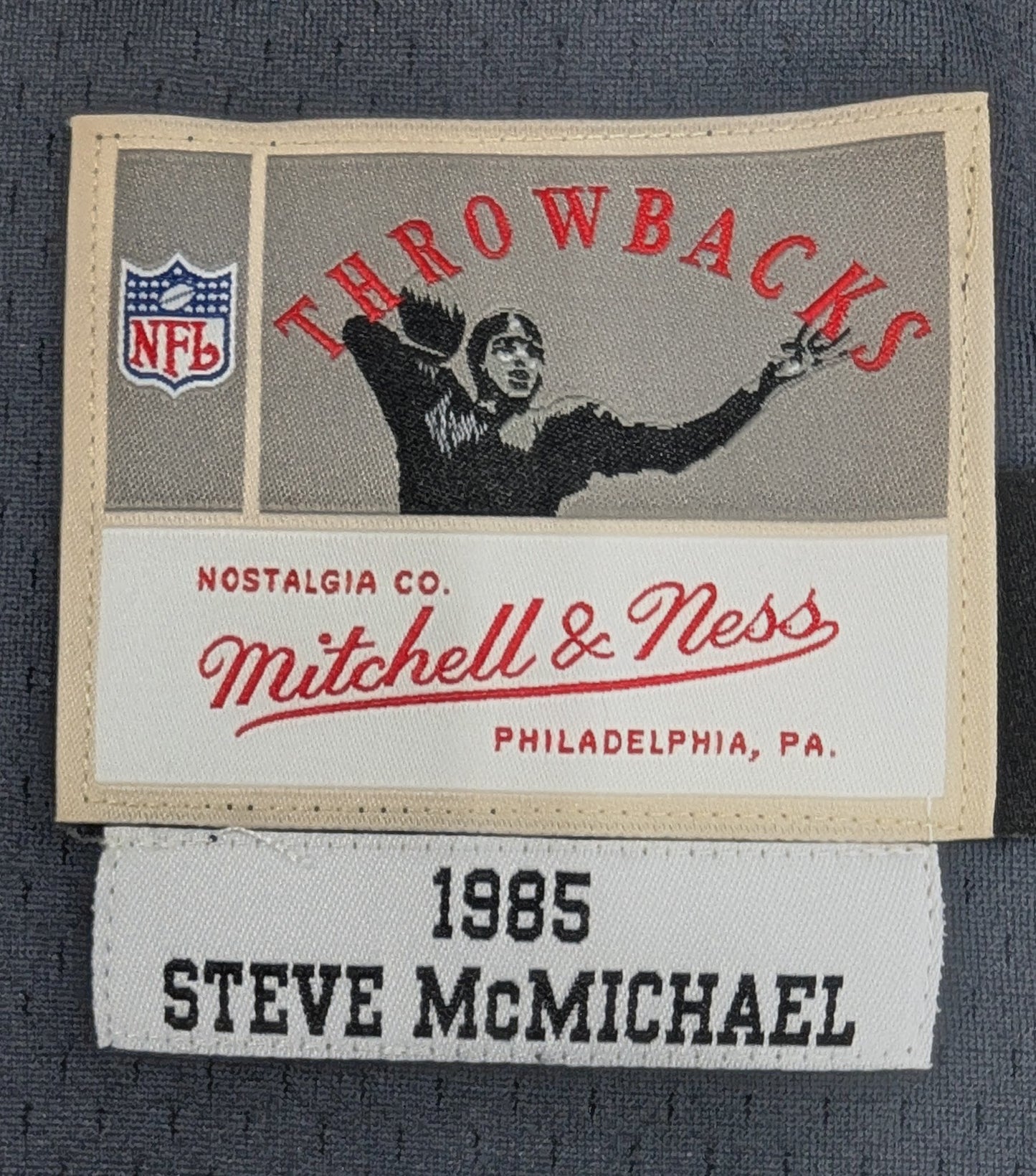 Mitchell & Ness label with NFL logo on a dark fabric background
